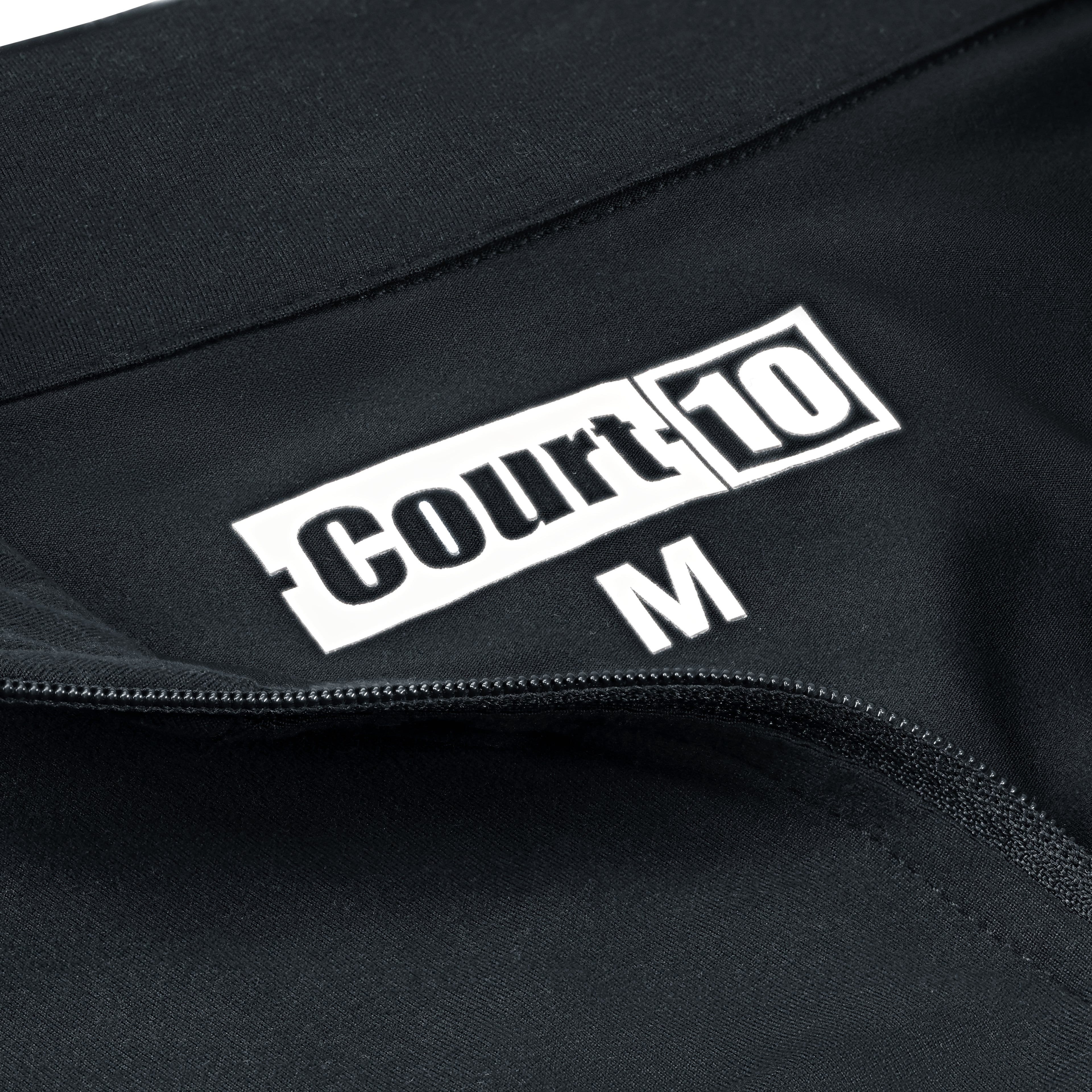 Open zip neckline detail with 'Court10' logo and size 'M' on black Performance Long Sleeve