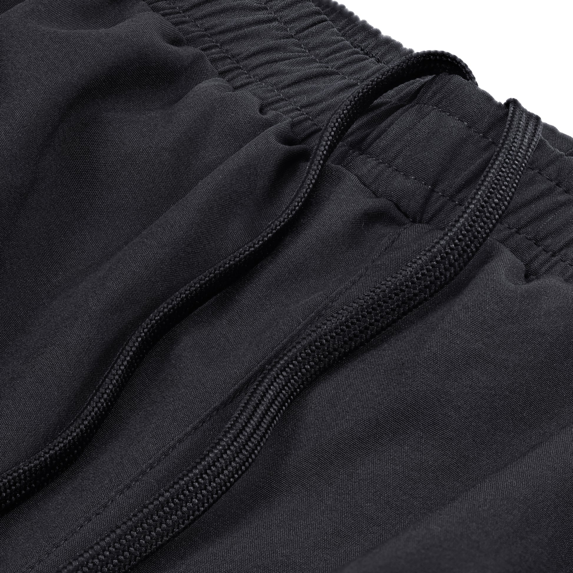 Close-up of black Court10 Performance Shorts with drawstring detail on a white background